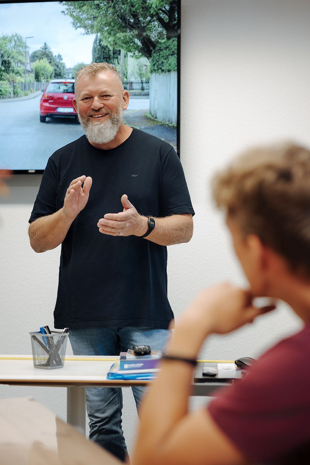 Fahrlehrer erklärt im Theorieunterricht eine Verkehrssituation